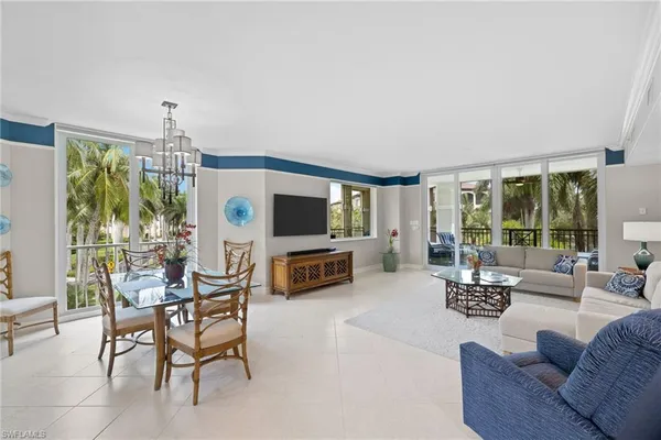 a living room with furniture a flat screen tv and a large window