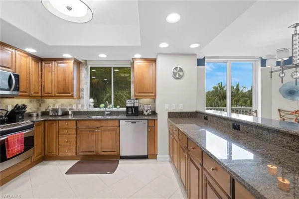a kitchen with stainless steel appliances granite countertop a stove a sink and a refrigerator