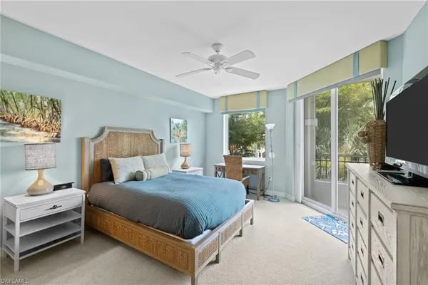 a bedroom with a bed and a flat screen tv on dresser