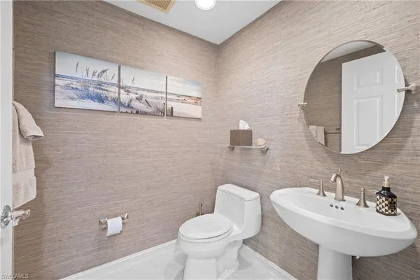 a bathroom with a sink toilet and mirror