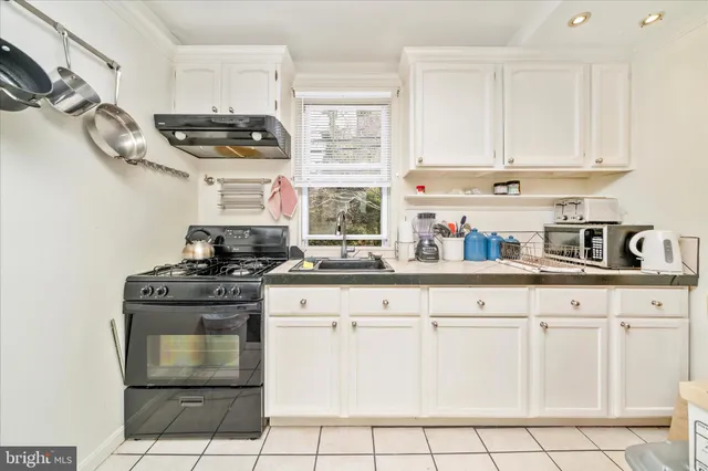 a kitchen with white cabinets and appliances