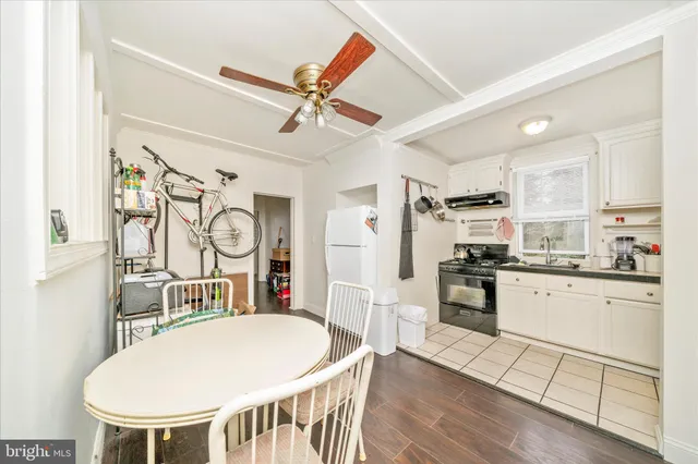 a living room with stainless steel appliances furniture a dining table and chairs