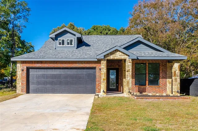 a front view of a house with a yard outdoor seating and garage