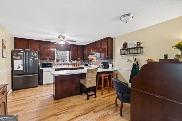 a kitchen with stainless steel appliances a stove a refrigerator cabinets and a dining table