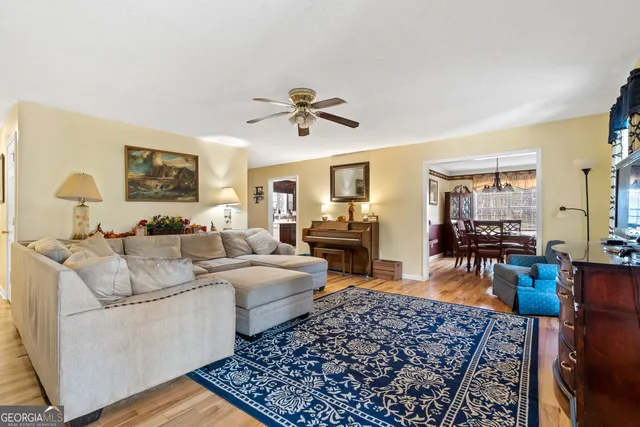 a view of a dining room with furniture a chandelier and wooden floor