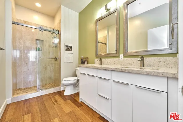a bathroom with a granite countertop sink toilet a large mirror and shower