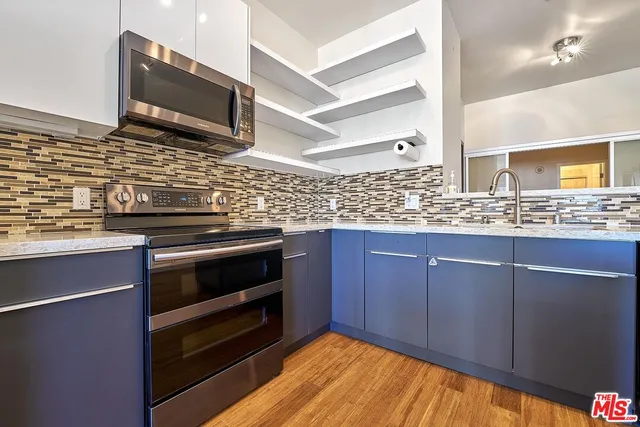 a kitchen with stainless steel appliances wooden cabinets and a stove top oven