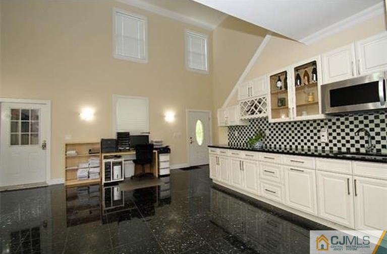 28 Chandler Road Edison, NJ 08820 - Photo 19 of 25 a kitchen with granite countertop white cabinets and black appliances