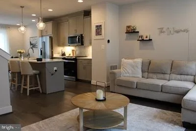 a living room with furniture and a dining table with kitchen view