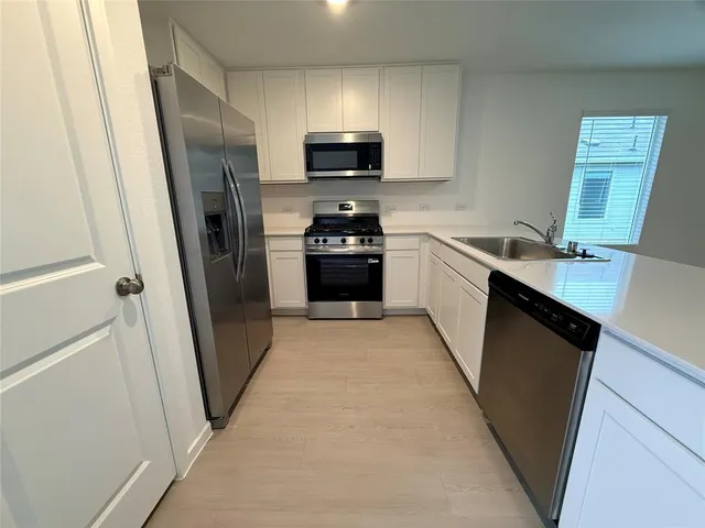 a kitchen with stainless steel appliances a refrigerator stove and sink