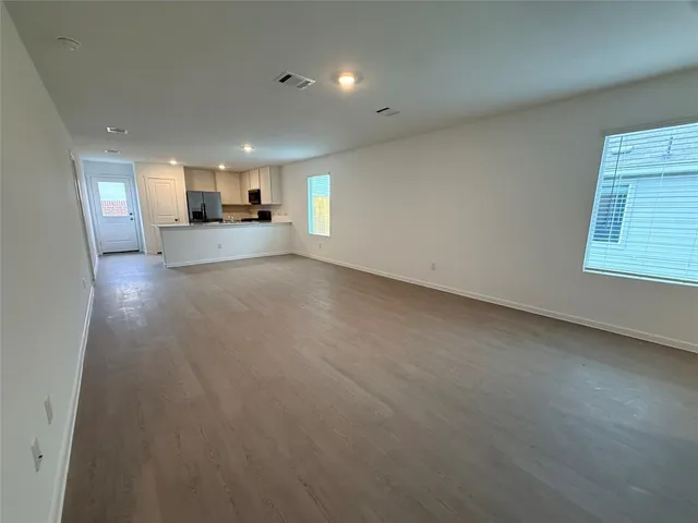 a view of empty room with a kitchen