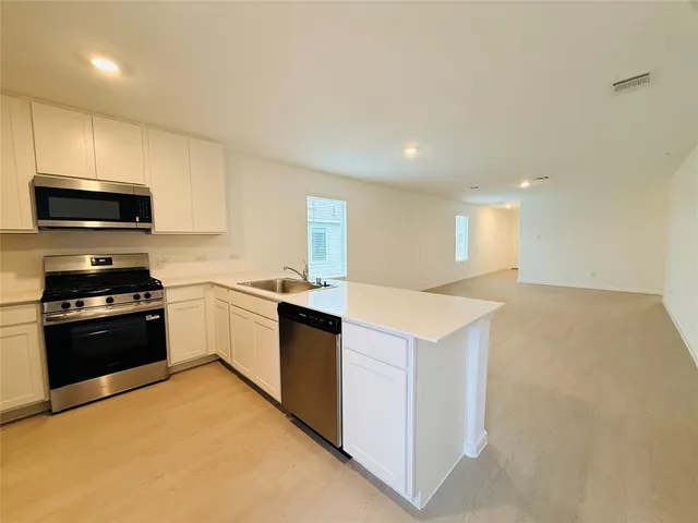 a kitchen with a stove a sink and a refrigerator