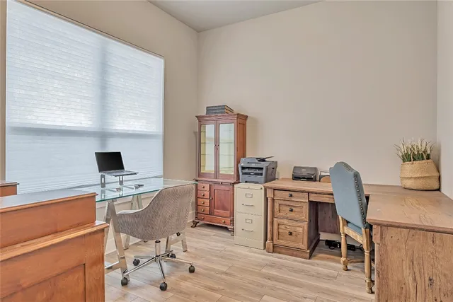 a view of a workspace with furniture and a window