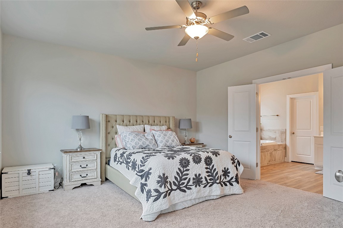 175 Brooks Ranch Drive Kyle, TX 78640 - Photo 17 of 30 a bedroom with a bed and a chandelier