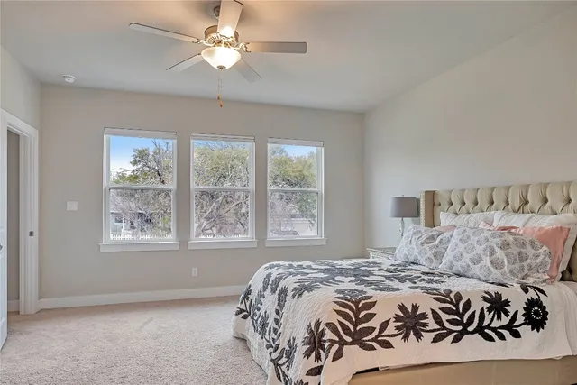 a bedroom with a large bed and a chandelier