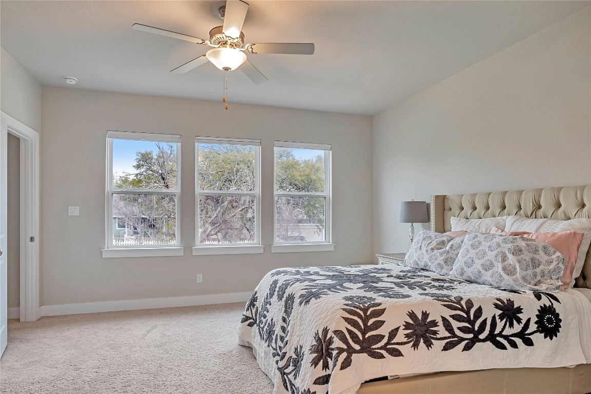 175 Brooks Ranch Drive Kyle, TX 78640 - Photo 18 of 30 a bedroom with a large bed and a chandelier
