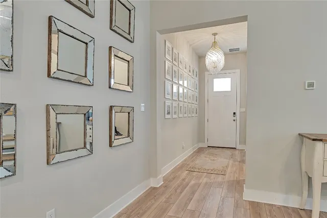 a view of a hallway with entryway wooden floor and windows