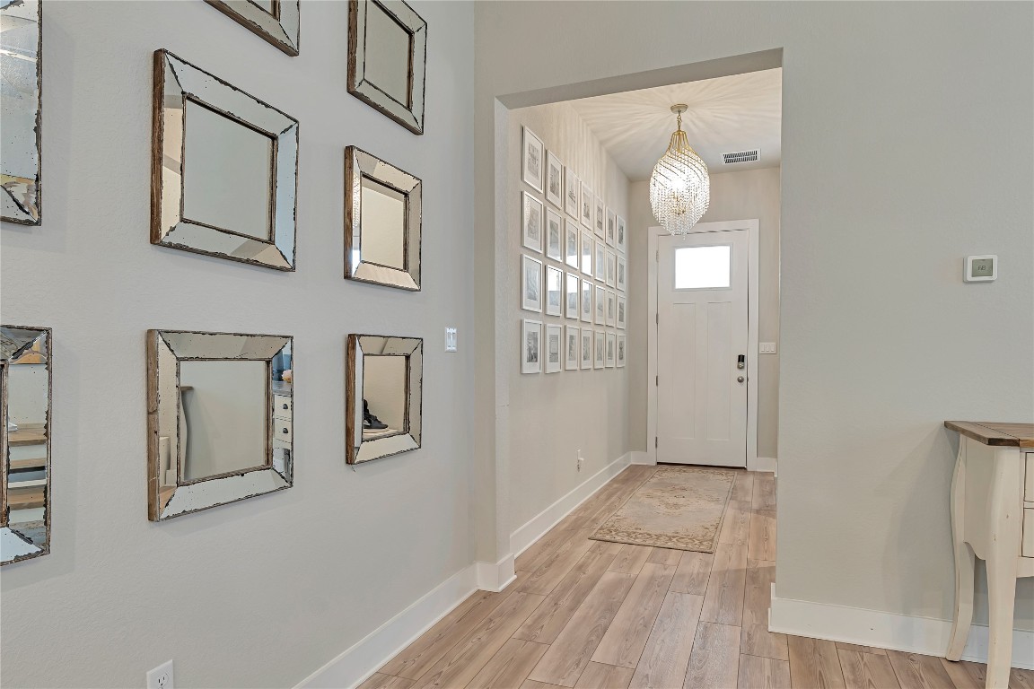 175 Brooks Ranch Drive Kyle, TX 78640 - Photo 2 of 30 a view of a hallway with entryway wooden floor and windows