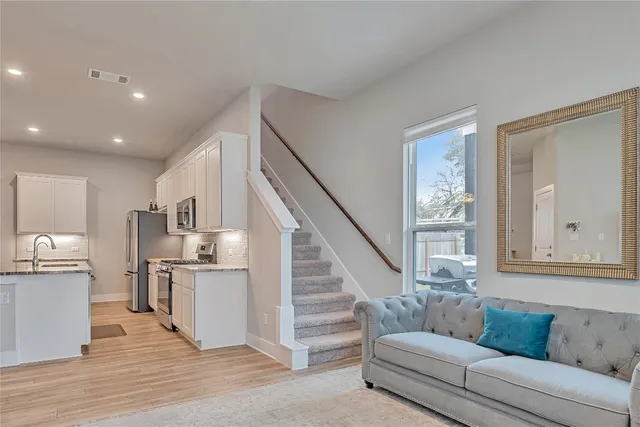 a living room with furniture and a wooden floor