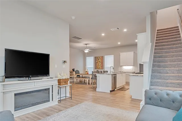 a living room with stainless steel appliances kitchen island furniture and a flat screen tv