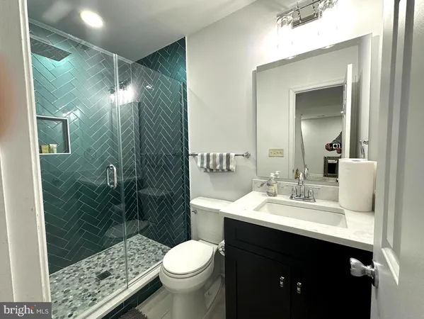a bathroom with a sink vanity granite toilet and a mirror