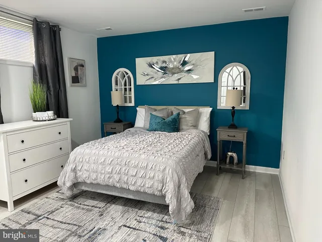 a bedroom with a bed and a dresser with mirror