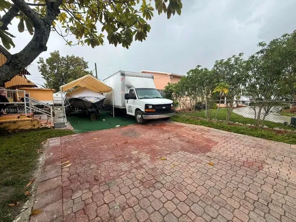 a couple of cars parked in front of a house