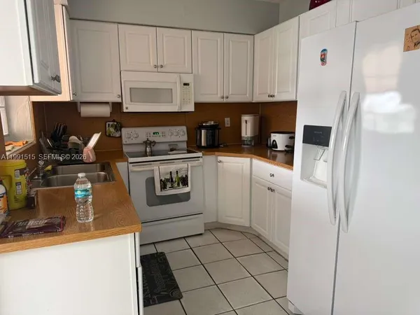 a kitchen with white cabinets and white appliances