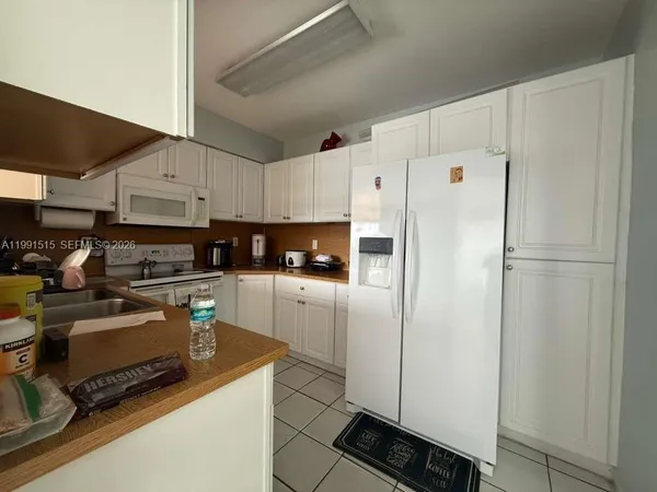 a kitchen with stainless steel appliances a refrigerator sink stove and white cabinets
