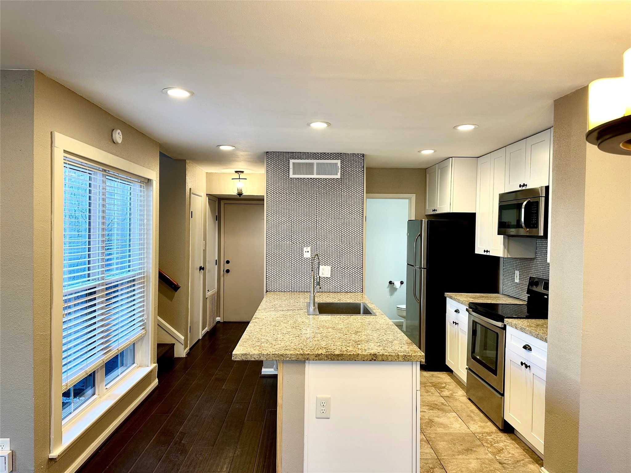 3200 South Gessner Road, Unit 330 Houston, TX 77063 - Photo 5 of 27 a kitchen with stainless steel appliances kitchen island granite countertop a refrigerator and a stove top oven