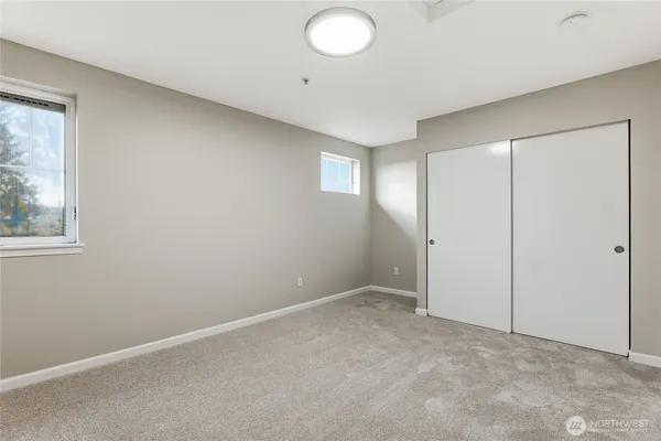 an empty room with windows and closet