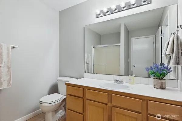 a bathroom with a sink a toilet and a mirror