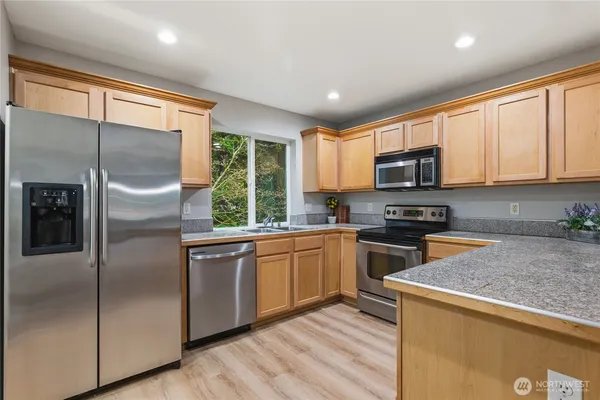a kitchen with a refrigerator a sink and cabinets