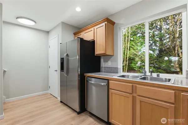 a kitchen with white cabinets and a window