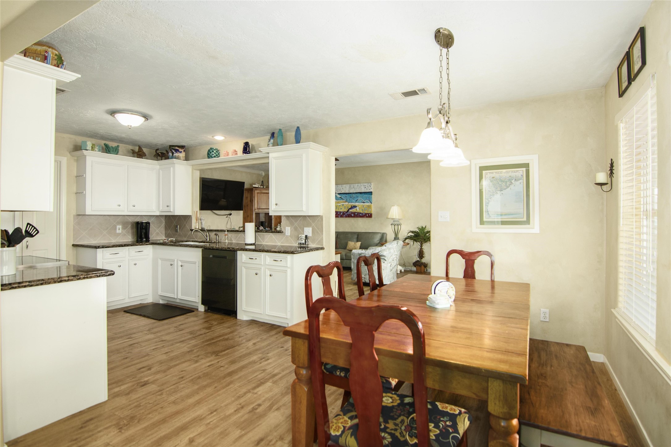 3933 Biscayne Beach Road Port Bolivar, TX 77650 - Photo 7 of 24 a kitchen with a dining table chairs and white cabinets