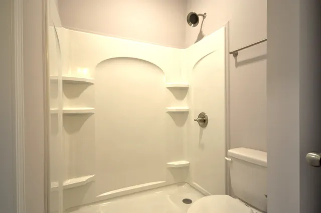 a bathroom with a toilet and a shower