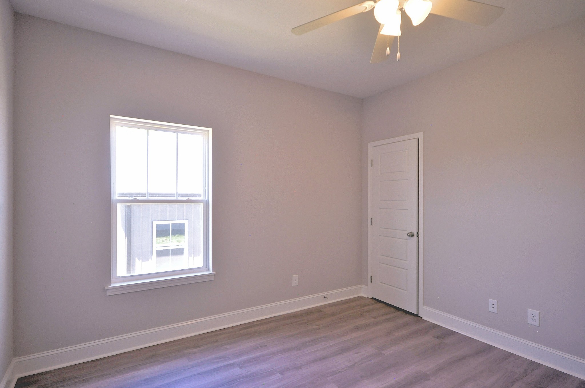 179 Bainbridge Drive, Unit A Clarksville, TN 37043 - Photo 25 of 33 an empty room with wooden floor chandelier fan and windows