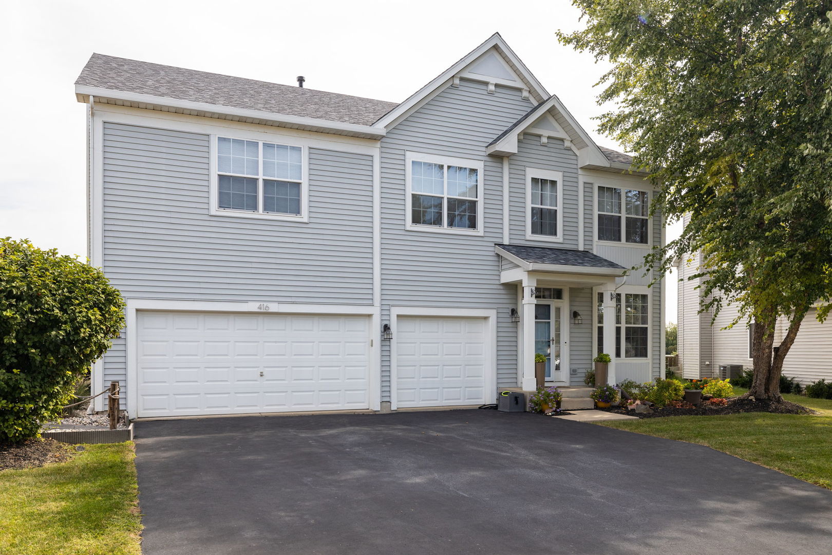 416 Hubbard Circle Plano, IL 60545 - Photo 2 of 57 a front view of a house with a yard and garage