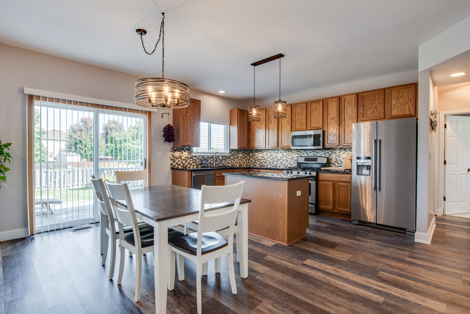 416 Hubbard Circle Plano, IL 60545 - Photo 8 of 57 a kitchen with stainless steel appliances granite countertop a refrigerator a stove a kitchen island a dining table and chairs