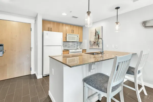 a kitchen with a table chairs refrigerator and microwave