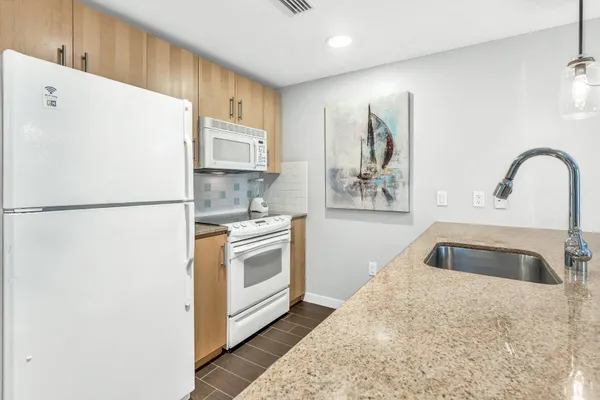 a kitchen with stainless steel appliances granite countertop a refrigerator sink stove and microwave