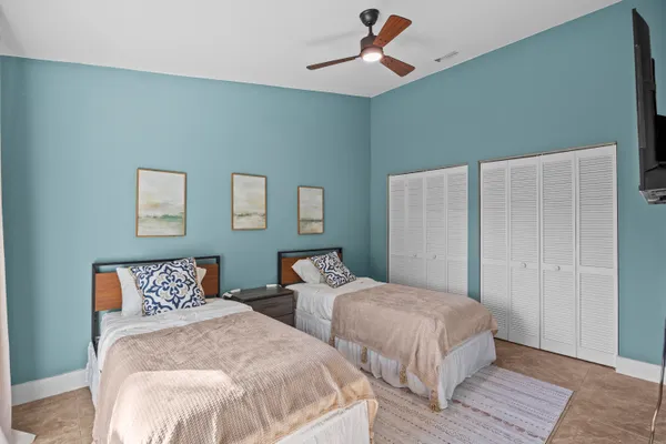 a bedroom with two beds and painting on the wall