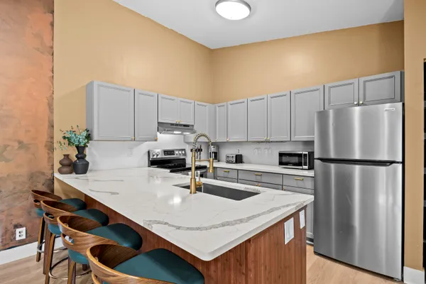 a kitchen with a sink a refrigerator and cabinets
