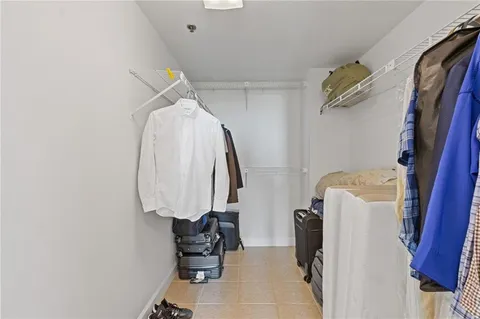 a view of walk in closet with clothes and shoes