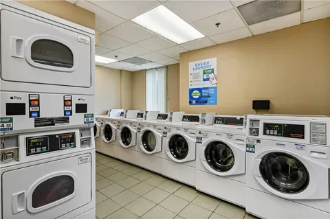 a utility room with dryer washer and a view of kitchen