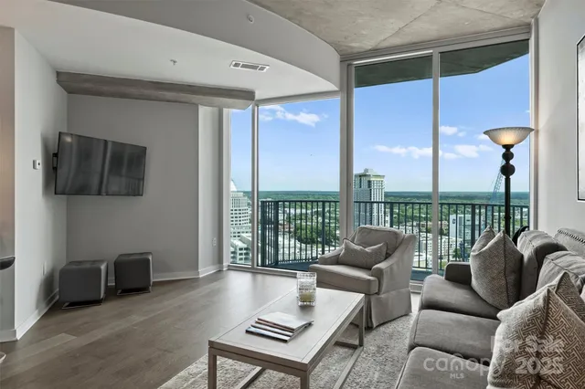 a living room with furniture and a floor to ceiling window