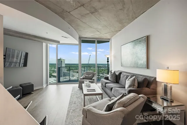a living room with furniture and a floor to ceiling window