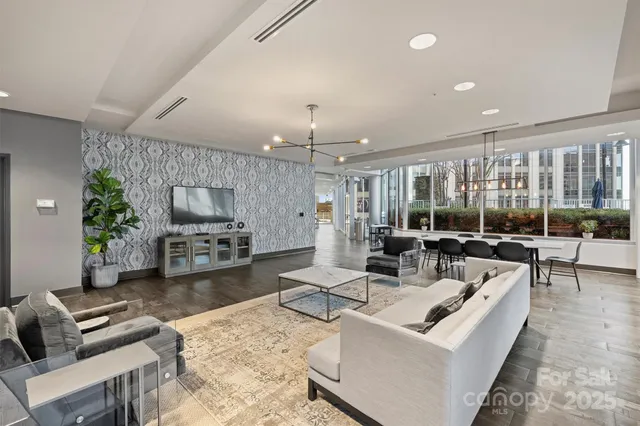 a living room with furniture a flat screen tv and a large window