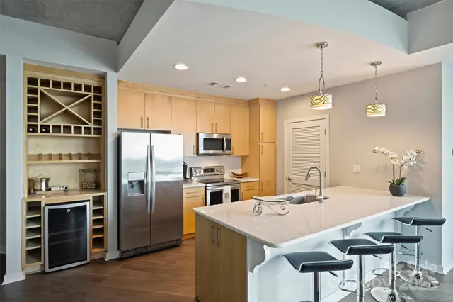 a kitchen with stainless steel appliances a sink a stove a refrigerator and island