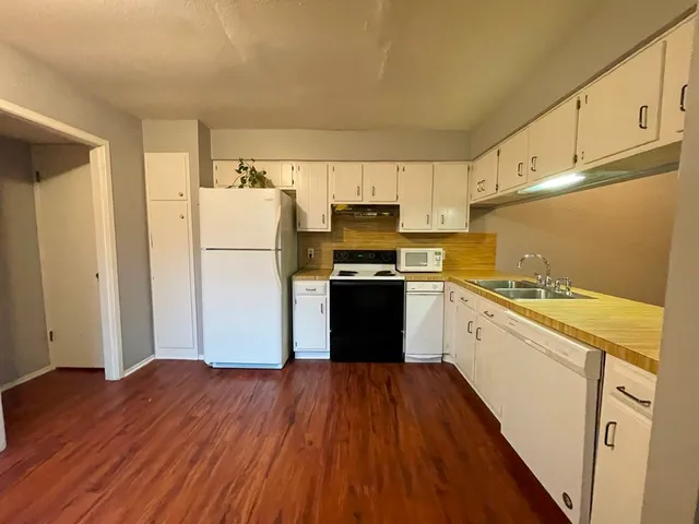 a kitchen with wooden floors and refrigerator